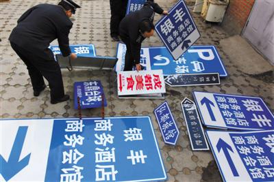 2009年12月8日,北京相关部门在整治行动中,拆除“山寨指路牌”。图/视觉中国