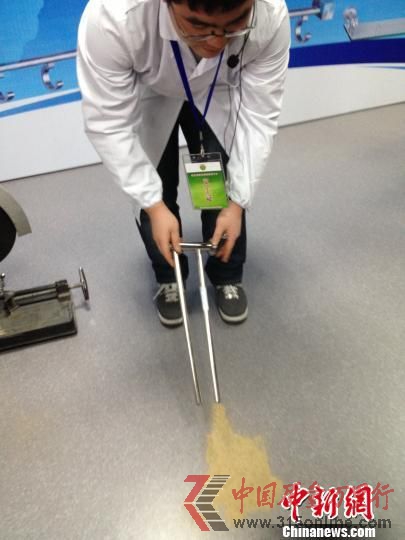 浙江消保委工作人员切割开被灌充进沙石的不合格“毛巾架” 肖娜 摄